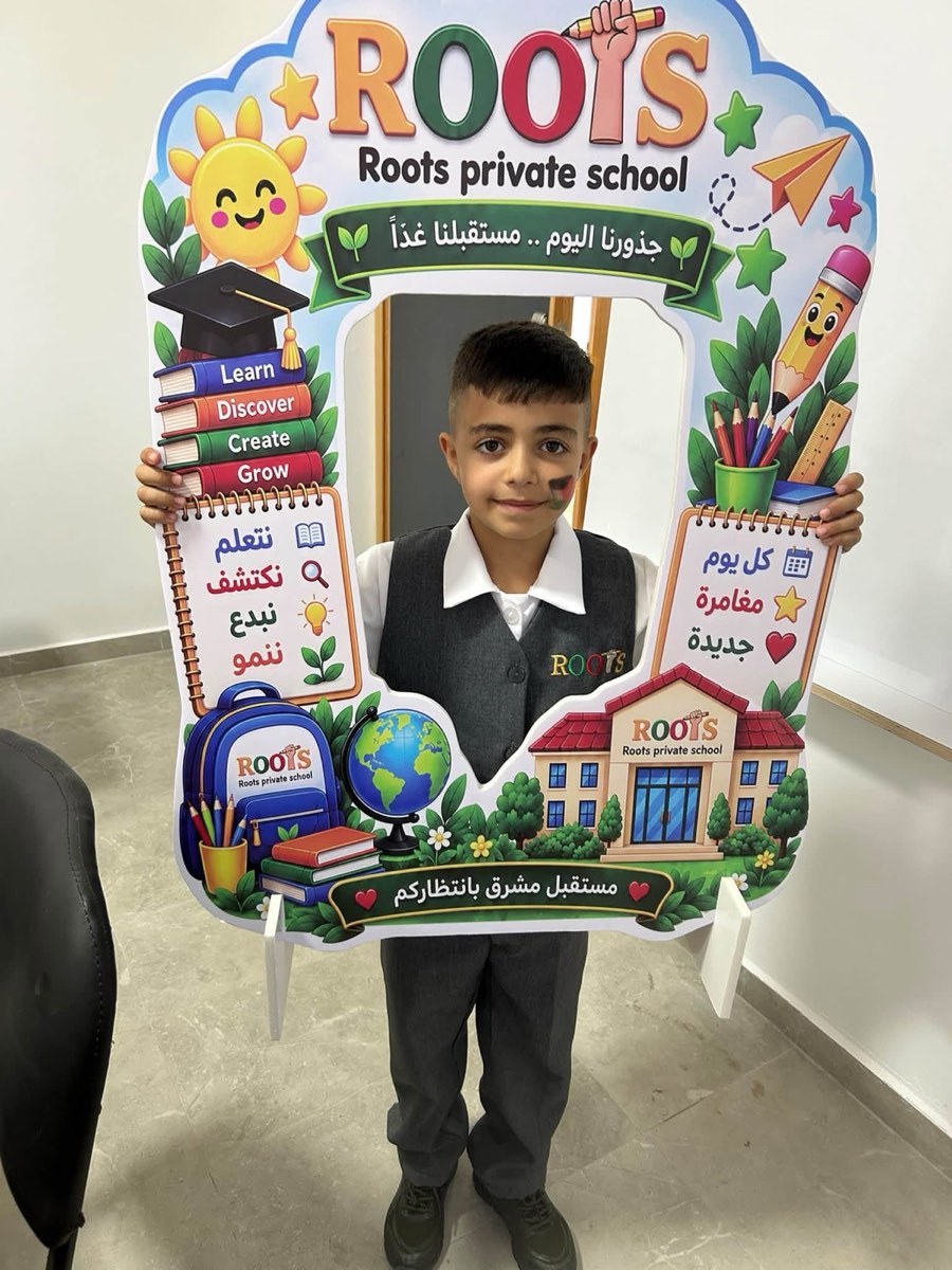 طالب من مدرسة الجذور يحمل إطار المدرسة